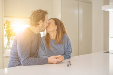 Romantik orta yaş çift birlikte oturan ve evde öpüşme