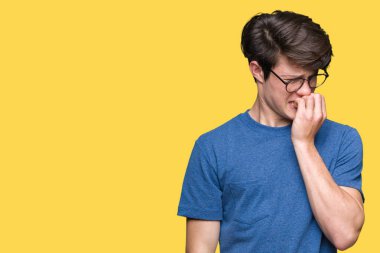 Genç yakışıklı adam stresli ve gergin ile izole arka plan üzerinde gözlük takan tırnak ısırma dudaklarından eller. Anksiyete sorunu.