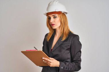 Takım elbise ve hardhelmet tutan flip board giyen genç güzel kızıl mimar kadın