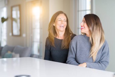 Anne ve kızı eve uzak tarafına gülümseme ile yüzünde, doğal ifade arıyorum birlikte güzel aile. Kendine güvenen gülüyor.