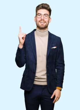 Başarılı fikirle parmağı yukarıyı gözlüklü genç yakışıklı iş adamı. Çıktıktan ve mutlu. Bir numara.