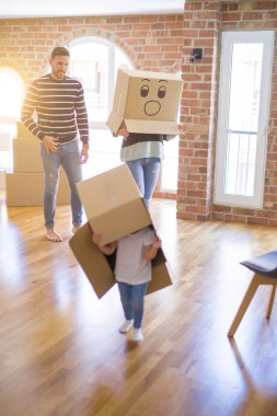 Yeni evde karton bel kutuları ile oynayan çocuk ile güzel famiily