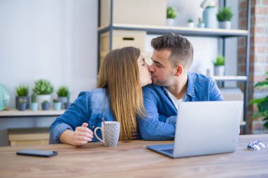 Genç çift bir kahve içme rahatlatıcı ve karton kutular etrafında bilgisayar laptop kullanarak, çok mutlu yeni bir eve hareket