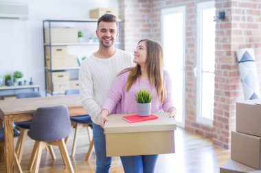 Yeni ev, yeni bir daire için çok mutlu ve neşeli karton kutular tutarak hareket aşk genç güzel çift