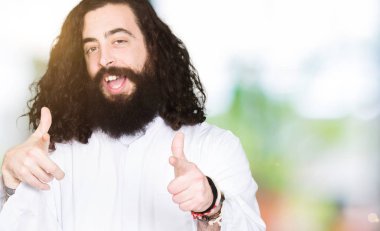 İsa Mesih giyen adam işaret parmak kamera ile mutlu ve komik yüz için kostüm. İyi enerji ve vibes.