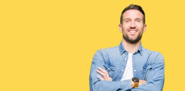 Denim ceket mutlu yüz çapraz silah kameraya bakarak ile gülümseyen giyen sakal ve mavi gözlü yakışıklı adam. Olumlu bir kişi.