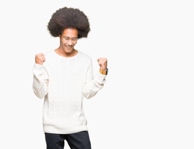 Gülümseyen ve başarı için çığlık genç Afro-Amerikan adam afro saçlı gözlüklü çok mutlu ve heyecanlı kaldırdı, silah ile kazanan jest yapıyor. Kutlama kavramı.