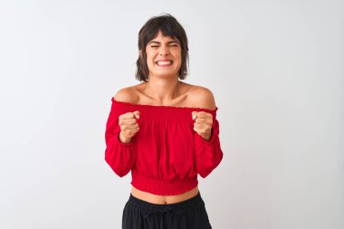 Kırmızı yazlık tişört giyen genç güzel kadın izole beyaz arka plan üzerinde duran kollarını kaldırdı ve gözleri kapalı zafer gülümseyerek kutluyor başarı için heyecanlı. Kazanan kavramı.