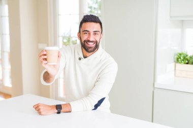 Bir kahve almak içerken gülümseyen yakışıklı adam 