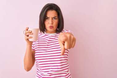 Genç güzel kadın kamera ve sizin için parmak ile işaret izole pembe arka planda ayakta kahve içme fincan, el işareti, ön pozitif ve emin jest