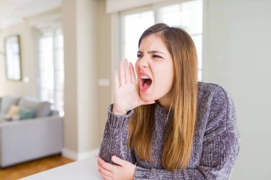 El ağızdan bağırarak ve ile yan için çığlık güzel genç kadın evde. İletişim kavramı.