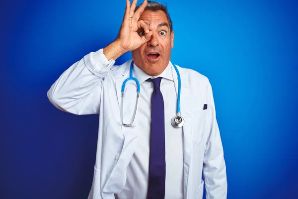 Gutaussehender Arzt Mittleren Alters Der Stethoskop Über Isoliertem Blauem Hintergrund — Stockfoto