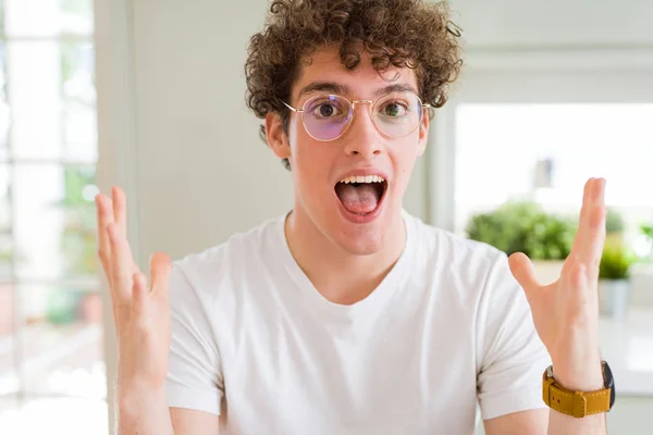 Młody Przystojny Mężczyzna Nosi Okulary Obchodzi Szalony Zdumiony Sukcesem Ramionami — Zdjęcie stockowe