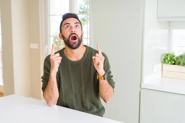 Hombre Hispano Guapo Usando Suéter Casual Casa Asombrado Sorprendido Mirando —  Fotos de Stock