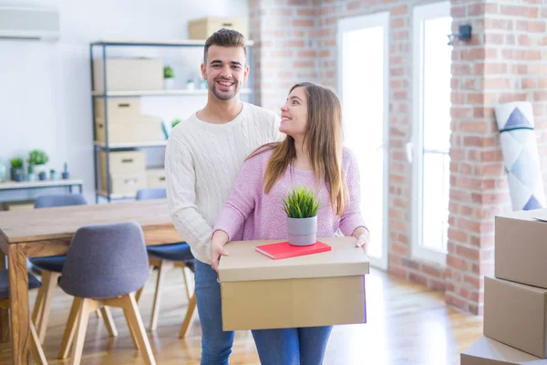 Yeni ev, yeni bir daire için çok mutlu ve neşeli karton kutular tutarak hareket aşk genç güzel çift