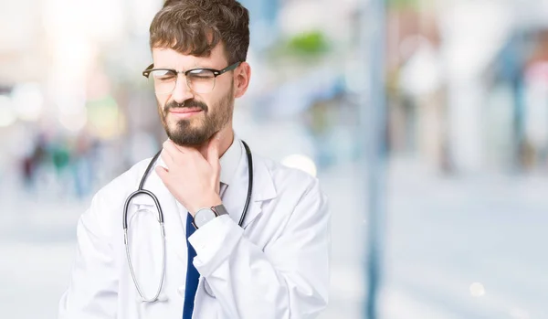 年轻的医生在孤立的背景上穿上医院外套触摸疼痛的脖子 喉咙痛的流感 血块和感染 — 图库照片