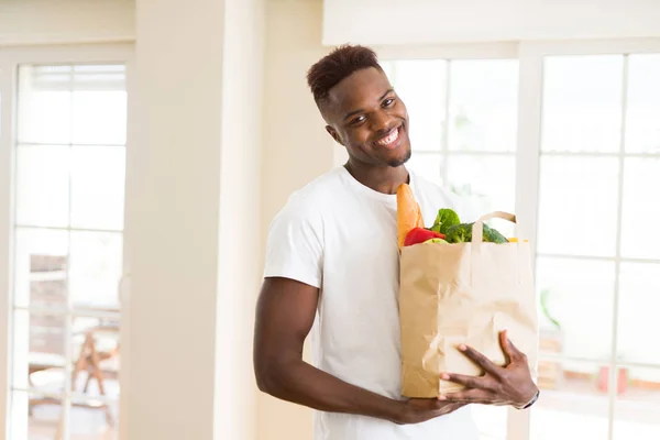 Afrikansk Amerikansk Mand Holder Papirpose Fuld Dagligvarer Glade Smilende Selvsikker - Stock-foto