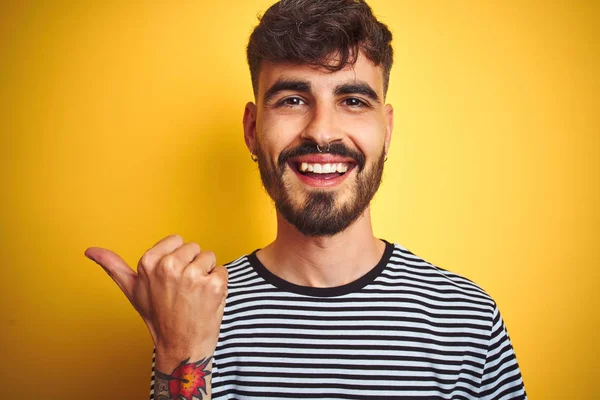 Junger Mann Mit Tätowierung Gestreiftem Shirt Vor Isoliertem Gelben Hintergrund — Stockfoto