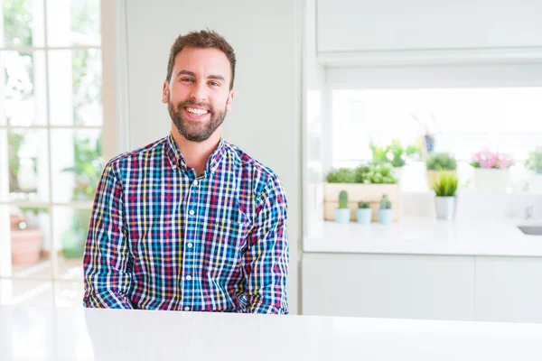 Beau homme portant une chemise colorée et souriant positif à la — Photo