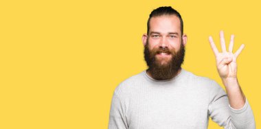 Gösterilen ve parmakları ile işaret rahat kazak giyen genç sarışın adam kendinden emin ve mutlu gülümseyerek süre dört numara.