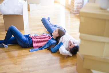 Genç Asya çift yatıyor üzerinde bu zemin bu yeni ev civarı karton kutular rahatlatıcı ve gülümseyen mutlu