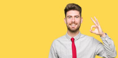 El ve parmak ile ok işareti yapıyor olumlu gülümseyen genç yakışıklı iş adamı. Başarılı ifade.