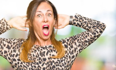 Leopar hayvan baskı çılgın elbise ve baş, korkuyor ve açık ağzı ile şok sürpriz elleriyle korkuttu güzel orta yaş kadın