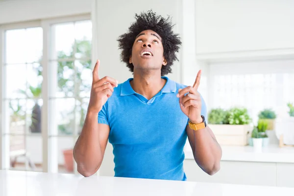 Hombre Afroamericano Casa Asombrado Sorprendido Mirando Hacia Arriba Señalando Con — Foto de Stock