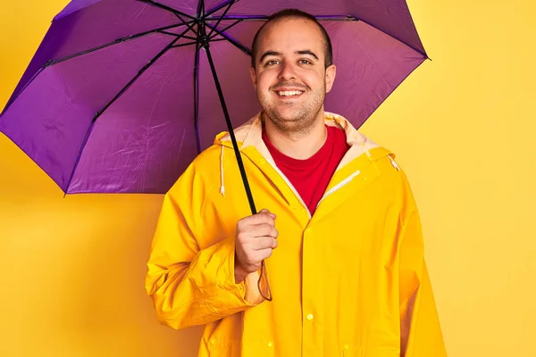 Young Man Wearing Raincoat Holding Purple Umbrella Standing Isolated Yellow — Stock Photo, Image