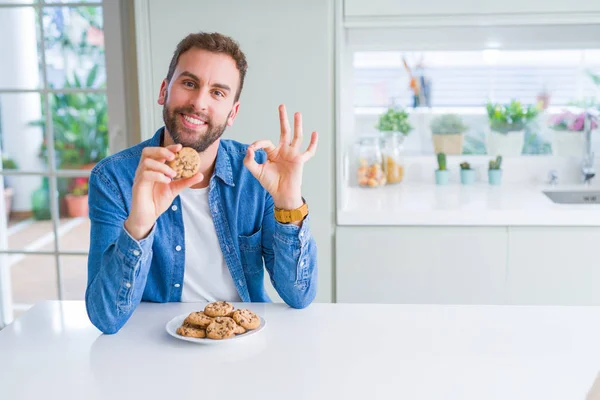 Hombre Guapo Comiendo Galletas Chocolate Haciendo Signo Con Los Dedos — Foto de Stock