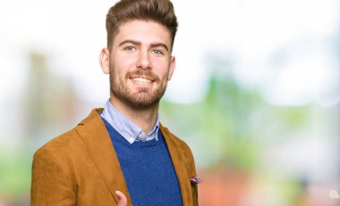 Genç yakışıklı iş adamı mutlu yaşasın el hareketini yapıyor. Kameraya bakarak başarı gösteren ile ifade onaylama.