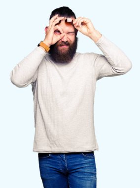 Genç hipster adam giyen güneş gözlüğü el gülümseyen, ok jest yapıyor göz parmakları ile mutlu yüz üzerinden seyir.