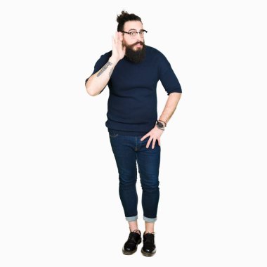Uzun saç ve sakal bir işitme söylenti ya da dedikodu için dinleme kulak üzerinde el ile gülümseyen gözlüklü genç hipster adam. Sağırlık kavramı.