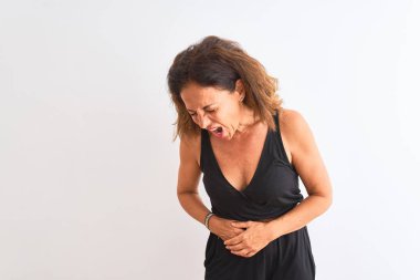 Orta yaş kadın siyah rahat elbise giyen mide üzerinde el ile izole beyaz arka plan üzerinde duran mide, ağrılı hastalık kötü hissediyorum çünkü. Ağrı kavramı.