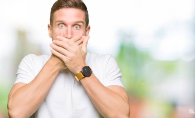 Yakışıklı adam ağız hata için elleriyle kapsayan şok Casual beyaz t-shirt giyiyor. Gizli kavramı.