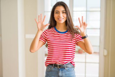 Rahat t-shirt gösterme ve parmakları ile işaret giyen genç güzel kadın kendinden emin ve mutlu gülümseyerek süre sekiz numara.