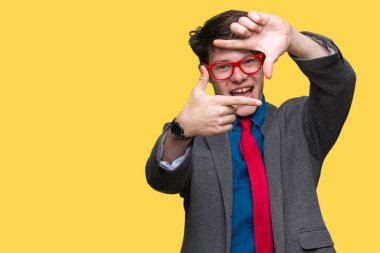 Elle yapma çerçeve ve parmakları ile mutlu yüz gülümseyen izole arka plan üzerinde kırmızı gözlük takan genç yakışıklı iş adamı. Yaratıcılık ve Fotoğrafçılık kavramı.