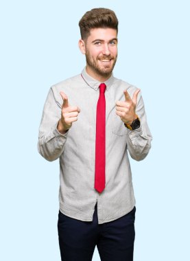 Genç yakışıklı iş adamı için fotoğraf makinesi ile mutlu ve komik yüz parmakları işaret. İyi enerji ve vibes.