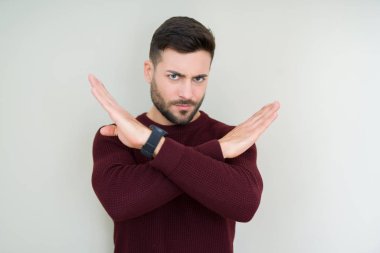 Genç yakışıklı adam izole arka plan reddi ifade geçiş kolları üzerinde bir kazak giyen olumsuz işaret yapıyor, kızgın yüz