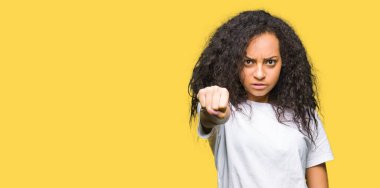 Kıvırcık saçlı rahat giyen genç güzel kız beyaz t-shirt kum yumruk mücadele için saldırgan ve kızgın saldırı, tehdit ve şiddet