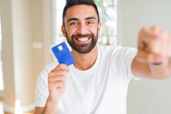 Hombre Hispano Guapo Sosteniendo Tarjeta Crédito Señalando Con Dedo Cámara —  Fotos de Stock