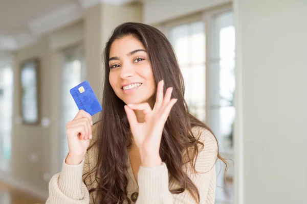 Junge Frau Hält Kreditkarte Als Zahlungsmittel Zeichen Mit Den Fingern — Stockfoto