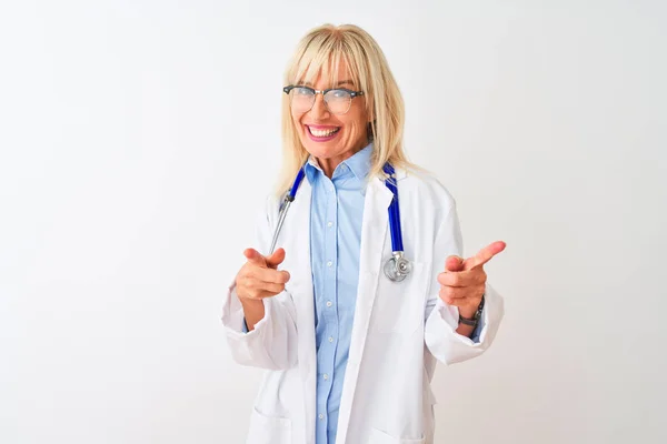 中年医生妇女戴着眼镜和听诊器在孤立的白色背景指着镜头与快乐和有趣的脸 良好的能量和氛围 — 图库照片