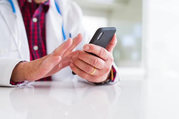 Close up of doctor man hands using smartphone and wearing stetho — Stock Photo, Image