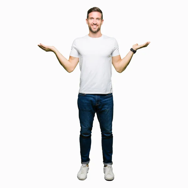 カジュアルな白い シャツ笑顔両方の手を示すを身に着けているハンサムな男を開き ヤシの木 提示広告比較とバランス — ストック写真