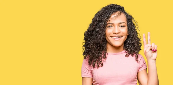 Mulher Bonita Nova Com Cabelo Encaracolado Vestindo Camiseta Rosa Mostrando — Fotografia de Stock