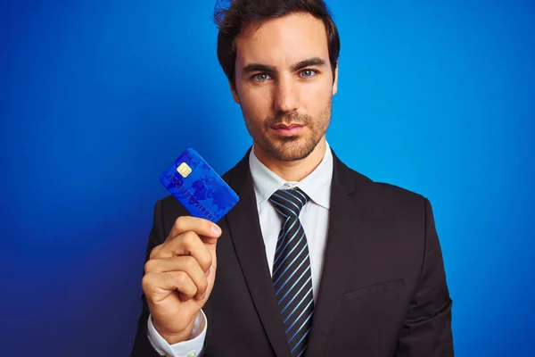 Jonge Knappe Zakenman Holding Creditcard Staande Geïsoleerde Blauwe Achtergrond Met — Stockfoto