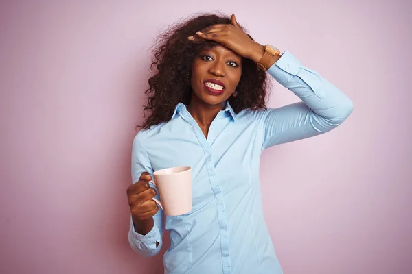 孤立したピンクの背景の上にコーヒーを飲む若いアフリカ系アメリカ人女性は 頭の上に手でストレスを感じ 恥と驚きの顔でショックを受け 怒りとイライラしました 間違いに対する恐怖と動揺 — ストック写真
