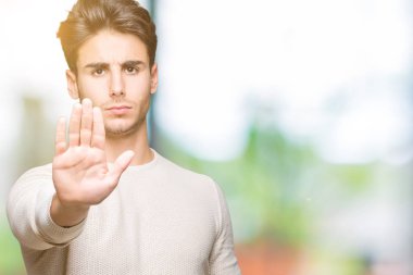 Yakışıklı delikanlı dur yapıyor izole arka plan üzerinde şarkı elin avuç ile. Negatif ve ciddi bir jest yüz ifadesiyle uyarı.