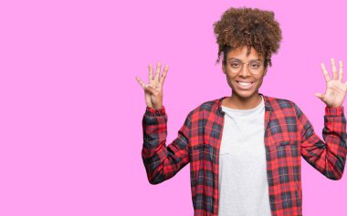 Güzel genç Afro-Amerikan kadın gözlük gösterilen ve parmakları ile işaret izole arka plan üzerinde dokuz kendinden emin ve mutlu gülümseyerek iken numara.